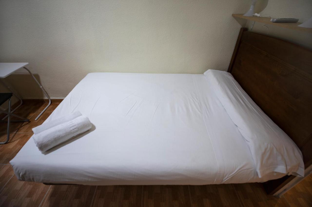 Hostal Los Perales Madrid Bagian luar foto A bed with a sheet