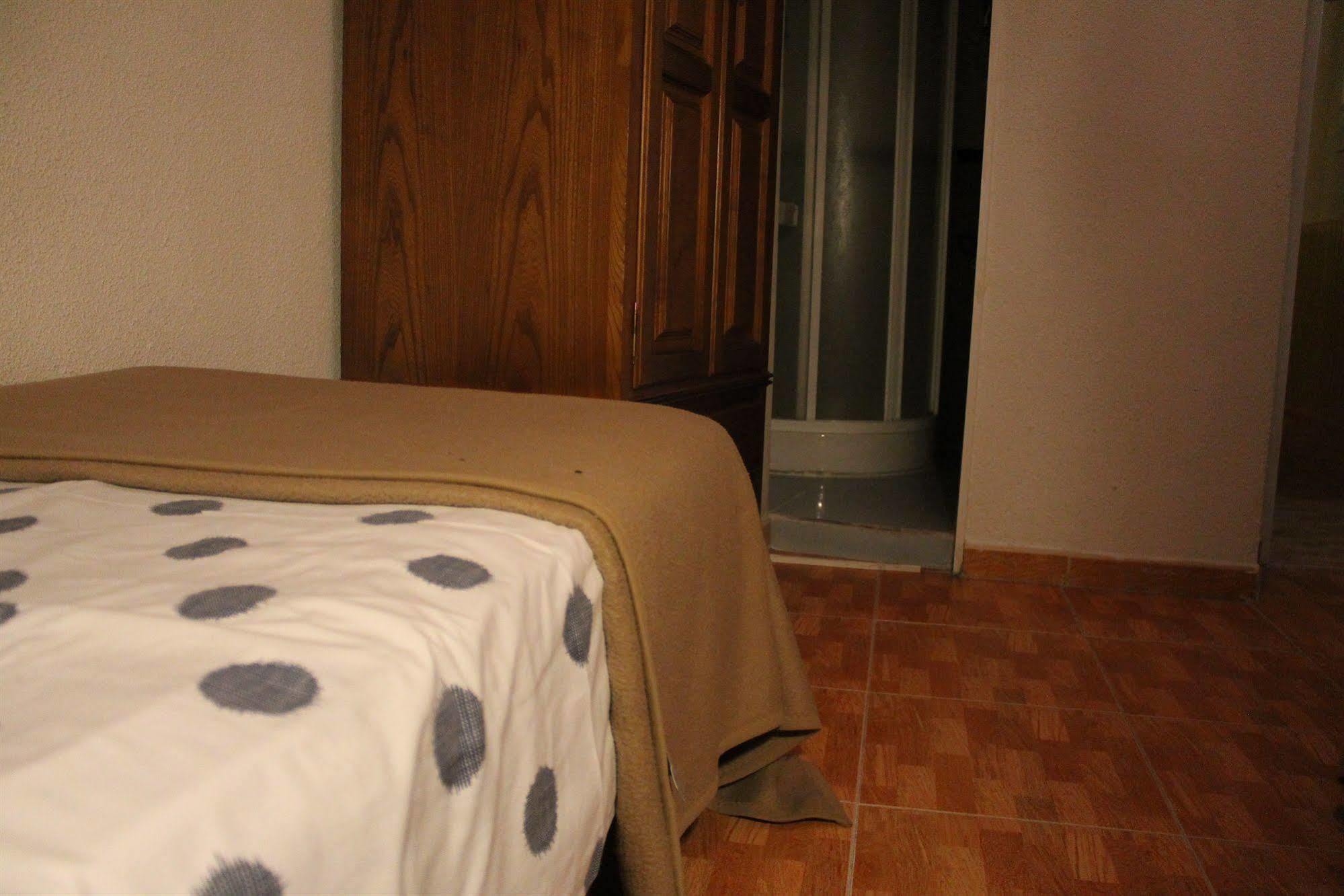 Hostal Los Perales Madrid Bagian luar foto A bed with a sábanas